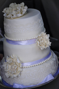 美丽的大纯白色三层蛋糕与花图片