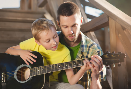 学习他弹吉他的儿子的父亲