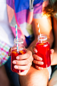 野餐主题 快乐的年轻家庭举行饮料, 烤面包瓶与红色果汁, 特写, 食品和饮料的概念