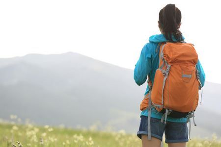 女人的徒步旅行者在草原的小路上行走