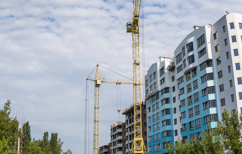 建筑施工中的起重机与建筑对抗蓝云天空