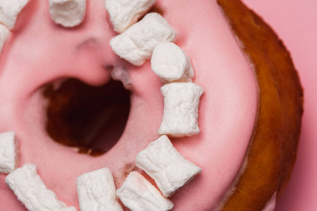 粉色甜甜圈和棉花糖粉红色甜甜圈的股票图像。粉红色背景上的甜甜圈。在粉红色背景下分离的甜甜圈
