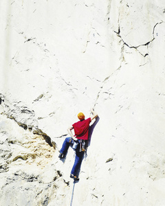 在悬崖上攀登挑战性路线的年轻人仰望