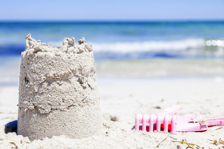 在夏季的海滩上的小沙子城堡