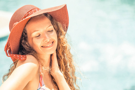 快乐的年轻女子穿着泳装在豪华度假胜地的游泳池里玩得很开心。暑期旅游度假理念
