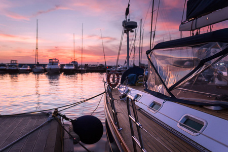 帆船与木甲板站立在海洋在美丽的日落
