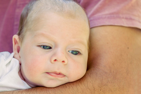 初生男婴躺在父亲的手臂上