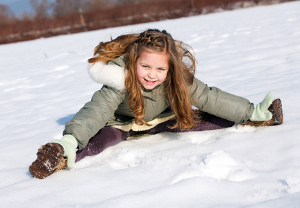 快乐的孩子在雪地里坐下来