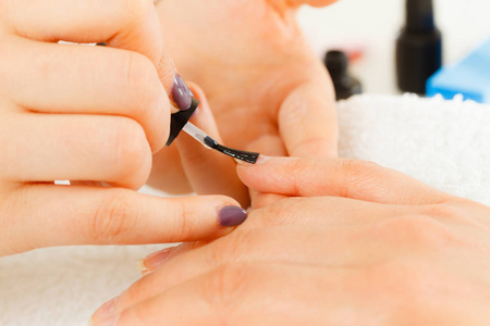 特写镜头的美容师画指甲的女性客户端。在美容院 spa 做指甲的女人