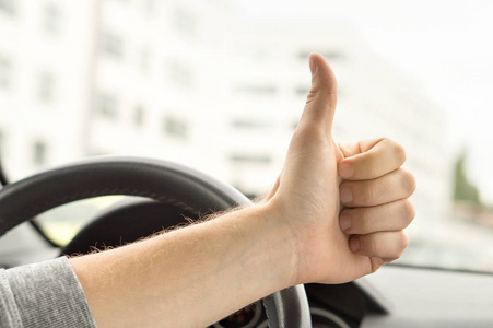 快乐的司机在车上竖起大拇指。对新车或没有交通满意。通过驾驶学校考试或车辆检查。车辆固定和修理