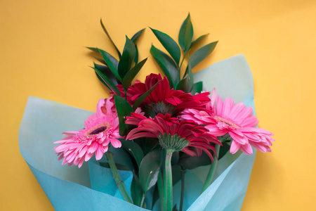 黄色背景上的粉红色和红色 gerberas 的花束