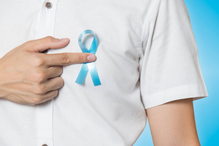 男性保健概念男性手接近蓝色背景左胸浅蓝色带状前列腺癌