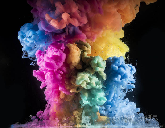五颜六色的彩虹颜料从上面的水中混合而出.水下旋转墨水