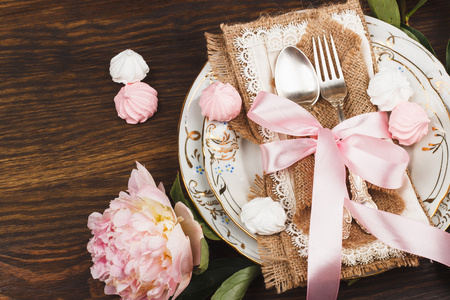餐具的淡粉色牡丹和蛋白甜饼图片