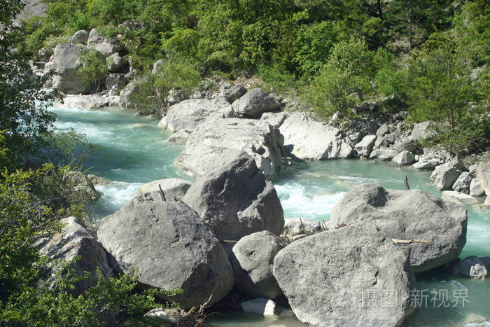 在法国 drome 山谷的 rimon 村附近, 清澈的淡蓝色湍急的河流与大岩石