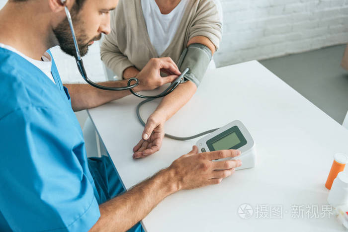 用听诊器测量老年妇女血压的男性护士镜头