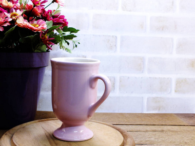 粉红色的咖啡杯和郁金香花装饰在木桌上