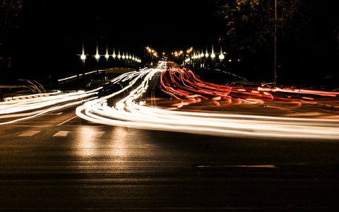 从汽车的车头灯的光线模糊与城市夜交通