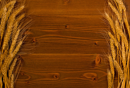 成熟的小麦，木制的背景，与文本的空间两侧的耳朵