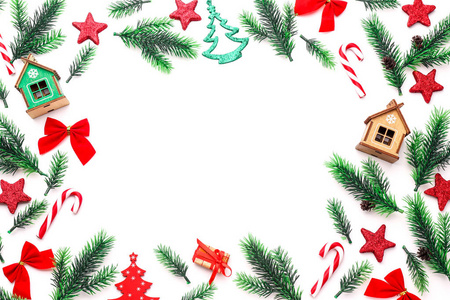 在白色背景下的杉木树枝和圣诞装饰品组成的框架