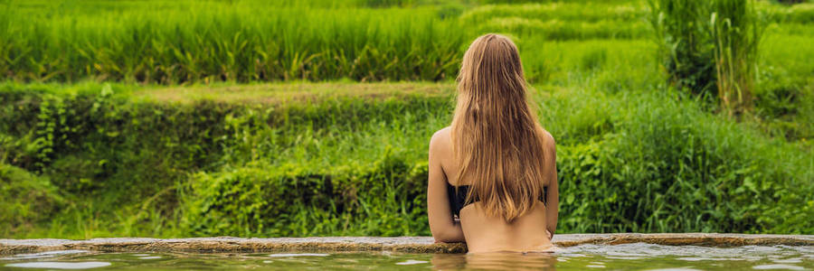 在印尼巴厘岛 Belulang 温泉泳池穿比基尼的年轻女子的后视