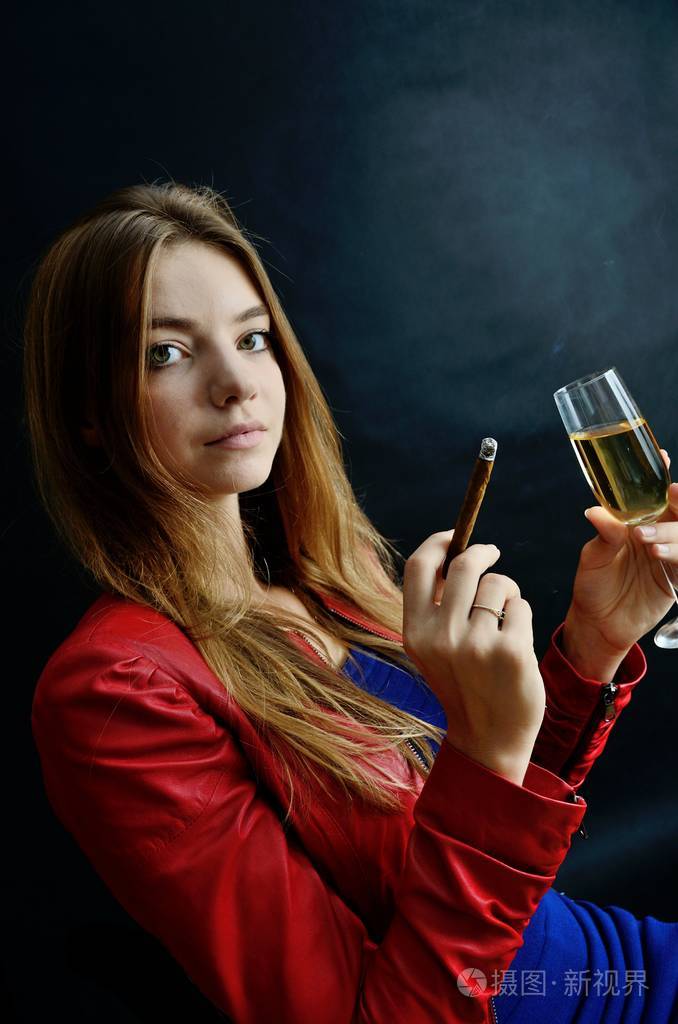 照片 年轻的女性坐在她的手 cigarillo 和白葡萄酒杯.穿红夹克的女人.
