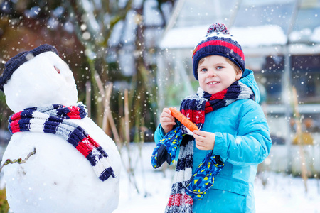 小小孩男孩在冬天堆雪人