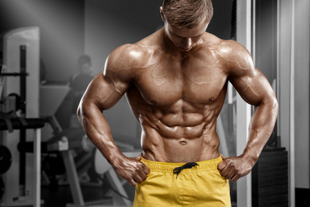 的健壮的男人，显示肌肉发达的身体和炫酷 abs 在健身房。强烈的男性闭塞躯干，工作