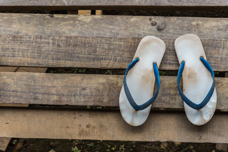 老式凉鞋或皮带或翻牌蓝色是在木制楼梯或地板上的鞋类