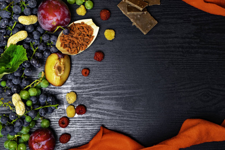 水果为健康, 食物富含白藜芦醇, 葡萄, 李子, 枸杞, 花生, 蔓越橘, raspberrys 巧克力在黑色木质背景