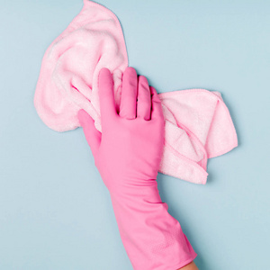 手在粉红色橡胶手套持有超细纤维布