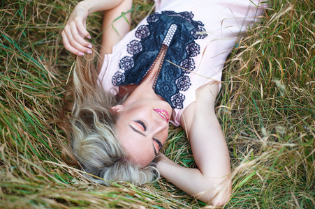 美丽的女人微笑，躺在草地上