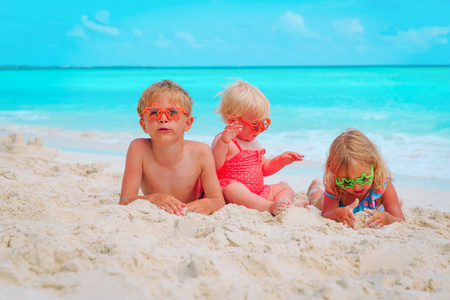 小男孩和女孩在海滩上玩沙子