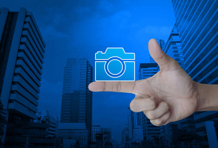 照相机平的图标在手指在现代室城市塔和摩天大楼, 商业照相机服务在线概念