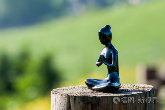 剪影的年轻健康的女性练瑜伽,冥想或祈祷在木质的表面