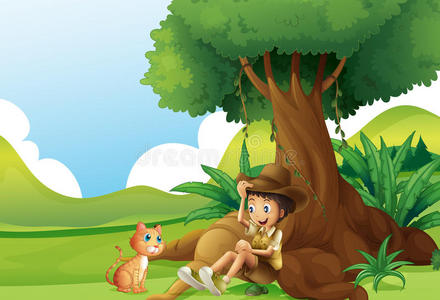 一个小男孩和一只猫在大树下