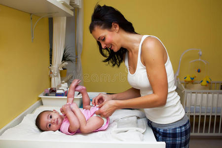 一位母亲给她的婴儿换尿布。