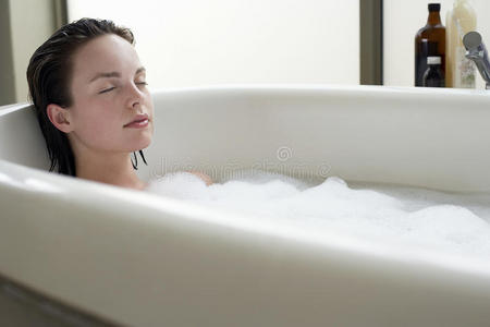在浴缸里闭着眼睛放松的女人