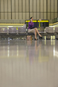 机场大厅使用手机的女商人