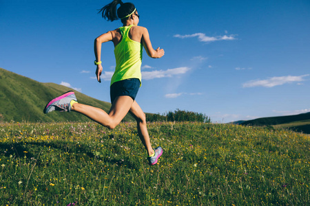 年轻健身女子小径赛跑者在草原上奔跑