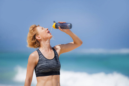 年轻快乐和有吸引力的运动亚军妇女饮水瓶或等渗饮料后, 在热带天堂海滩运行锻炼显示适合和运动身体健康的生活方式概念