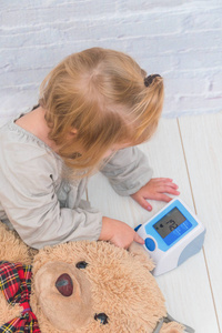 女孩, 孩子测量玩具熊的压力, 扮演医生