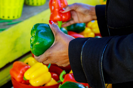 手持胡椒粉的妇女在选择黄色和红色胡椒超市特写的女人中吃新鲜的蔬菜
