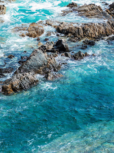在海中陡峭的岩石悬崖的看法。壮观的蓝色海和岩石海岸的景色