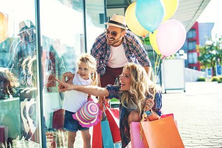 幸福的家庭，走在商场用购物袋和气球