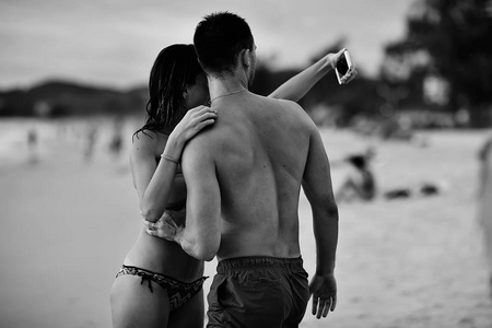 在沙滩上的情侣, 年轻的家伙和妇女在海边放松, 暑假的概念, 在海上度假