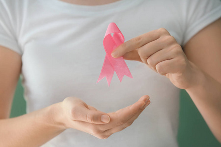 女人抱着粉红色的丝带, 特写。乳癌概念