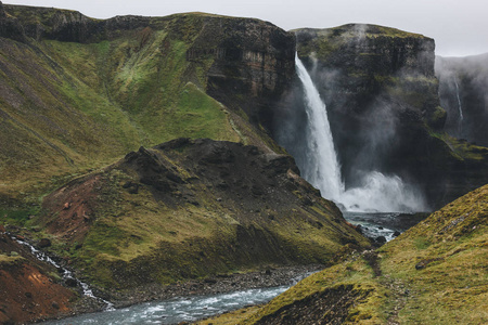 冰岛景观与 Haifoss 瀑布和绿色丘陵在薄雾日