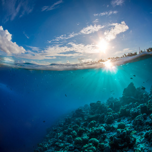 外海与水表面和太阳紫外线的珊瑚礁。天空和海洋云层
