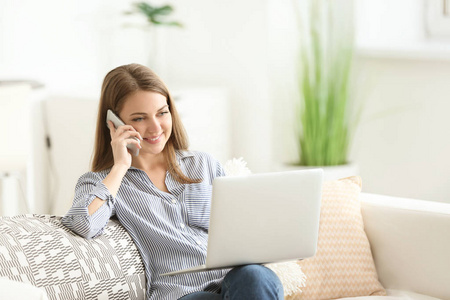 女性自由职业者的电话交谈时, 在家里的笔记本电脑